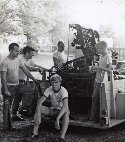 Pat Wyatt was always glad to accept discarded or obsolete printing machinery. Here he is moving a Linotype machine into the plant with the help of Mickey Henson, an unknown employee, and Pat's sons, Danny (seated) and Bobby. 
